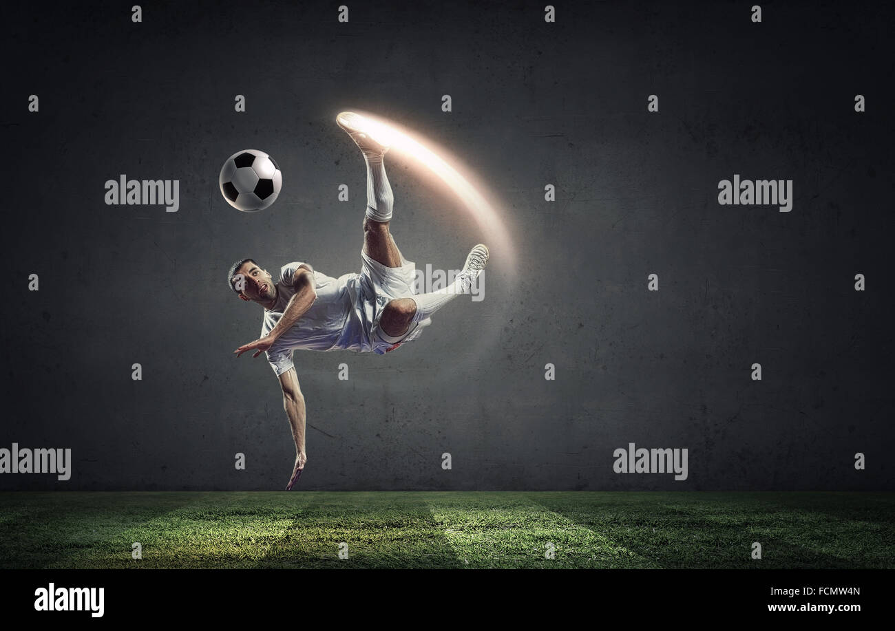 Football player in high jump taking ball Stock Photo