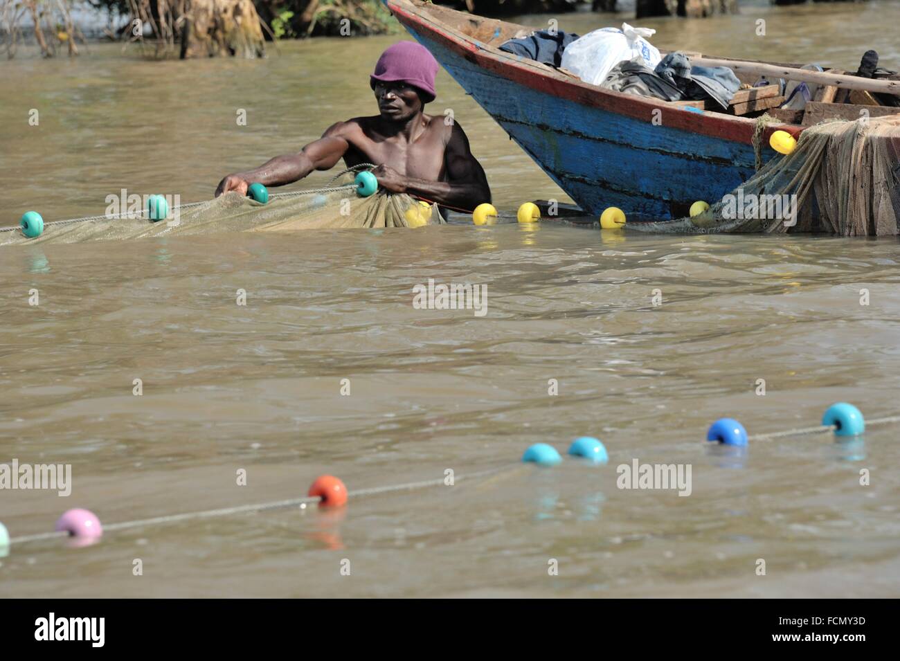 Fisher at work, man hauling big fishing net, Lake Victoria, Kenya Stock