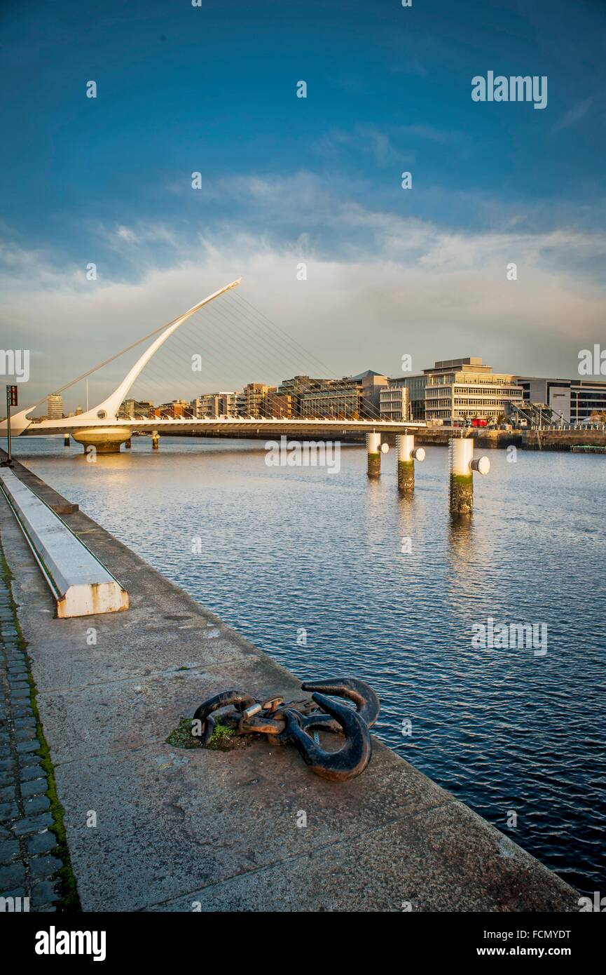 Rivers edge on the Liffey in Dublin with Jonathan Swift bridge in distance. Stock Photo