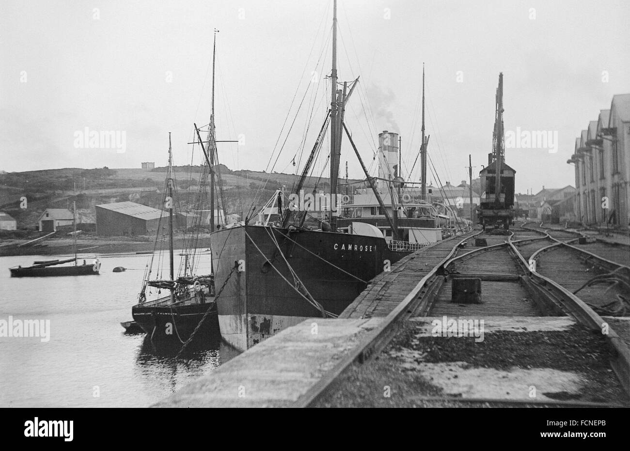 AJAXNETPHOTO.- 1920S APPROX. FALMOUTH, ENGLAND. - VIEW OF THE DOCKS WITH THE STEAM CARGO SHIP CAMROSE AND A FLAMOUTH REGISTERED SAILING SHIP MOORED ALONGSIDE.   PHOTO:AJAX VINTAGE PICTURE LIBRARY  REF:AVL SHI CAMROSE 1920 Stock Photo