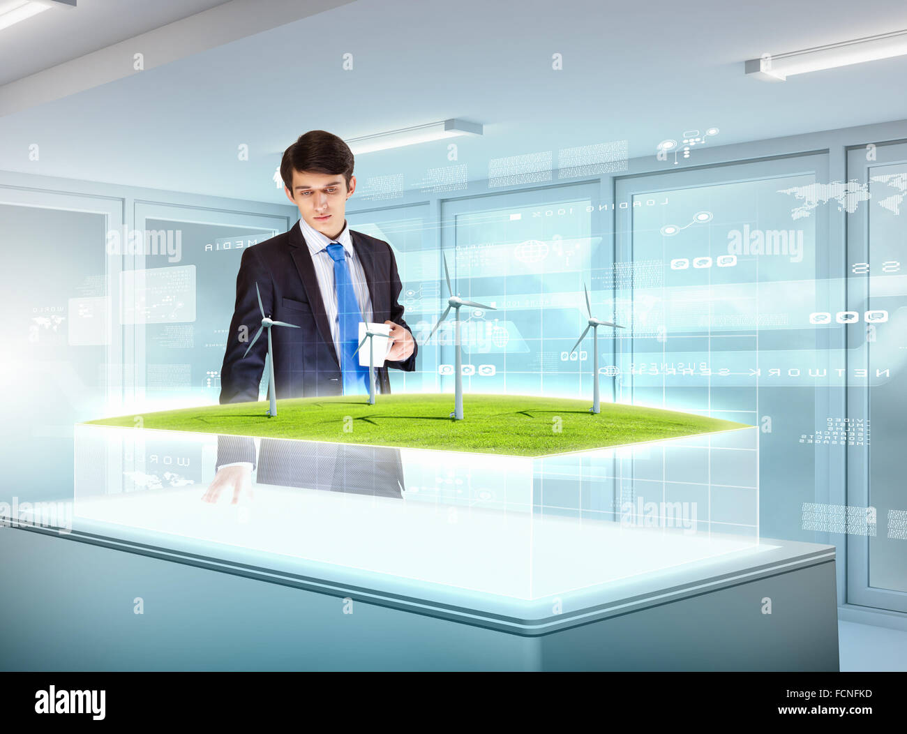 Image of young businessman looking at high-tech picture of windmills Stock Photo