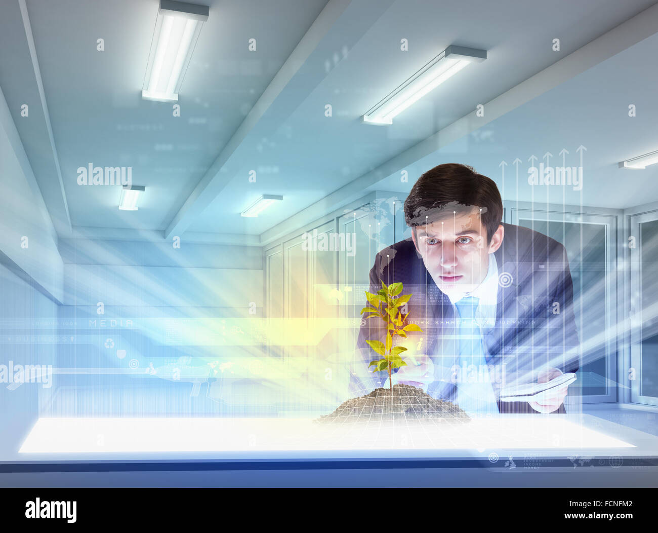 young businessman looking at high-tech image of sprig Stock Photo