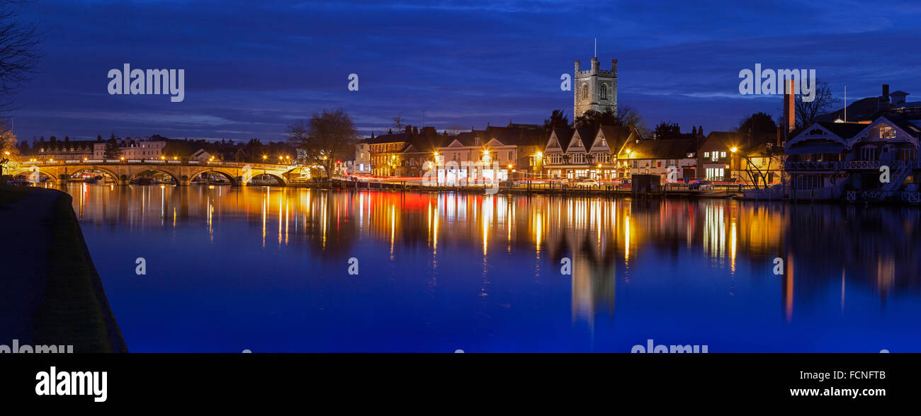 Dusk over the River Thames with the Oxfordshire town of Henley on Thames in the Background. Evening sky is blue and the town is reflected in the river Stock Photo