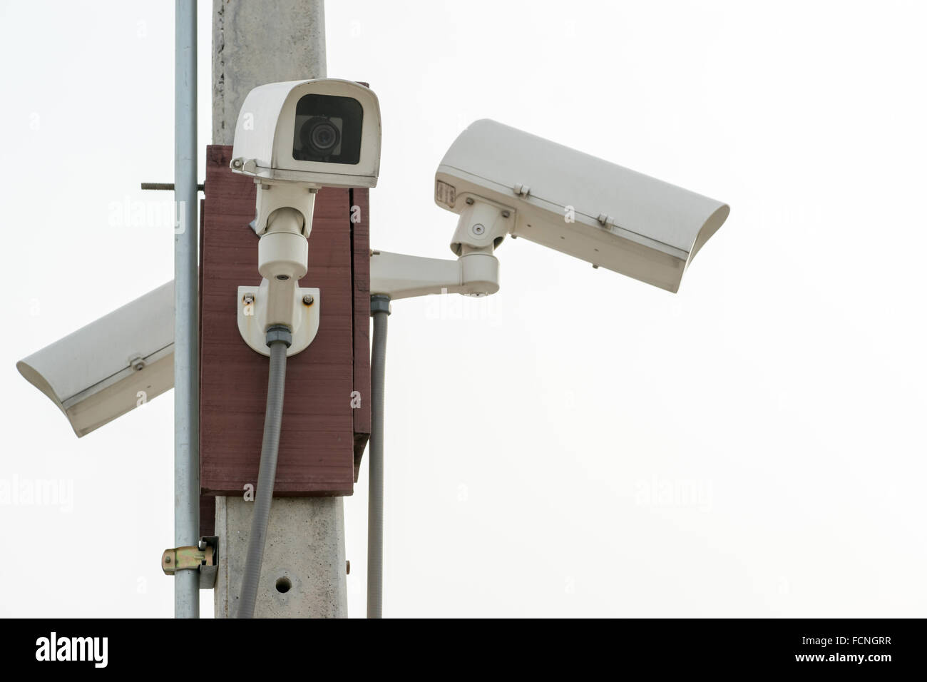 Three surveillance security cameras on white sky background with copy