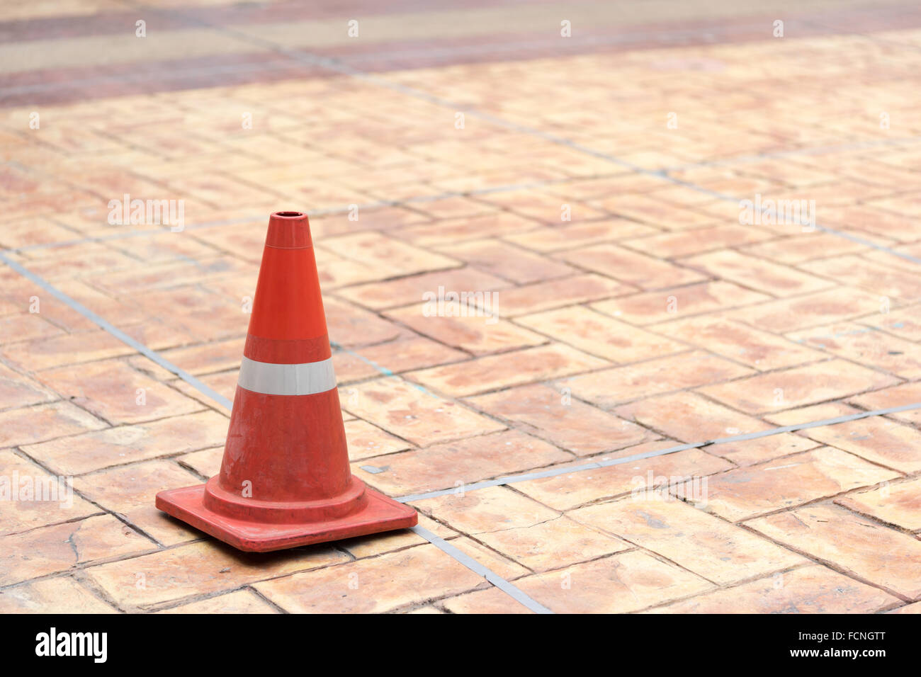 Red traffic cone on tiled rock pavement Stock Photo