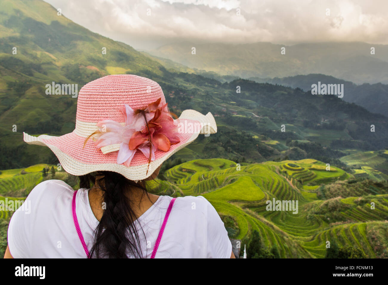 Girl with a pink hat looking the Dragon Backbone Rice Terraces Stock Photo