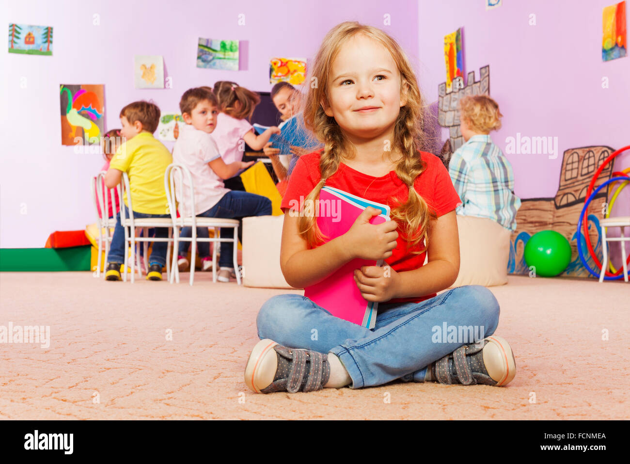 Portrait of little girl with books in class Stock Photo - Alamy
