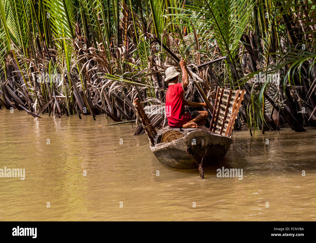 man in boat on the Mekong Delta collecting goods for local use the ...