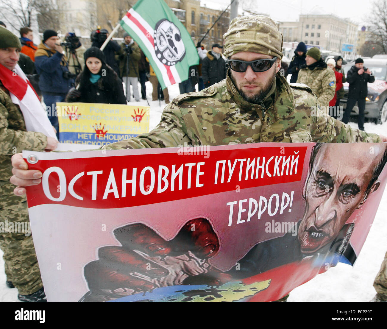 Kiev, Ukraine. 23rd Jan, 2016. An activist from Ukrainian voluntary battalion hold a placard reading 'Stop Putin's terror!' during protest of Ukrainian voluntary battalions 'Georgia national legion', Chechen battalion named of Dzhokhar Dudayev, and their supporters against the politics of Russian President Vladimir Putin, in front the Russian Embassy. © Vasyl Shevchenko/Pacific Press/Alamy Live News Stock Photo