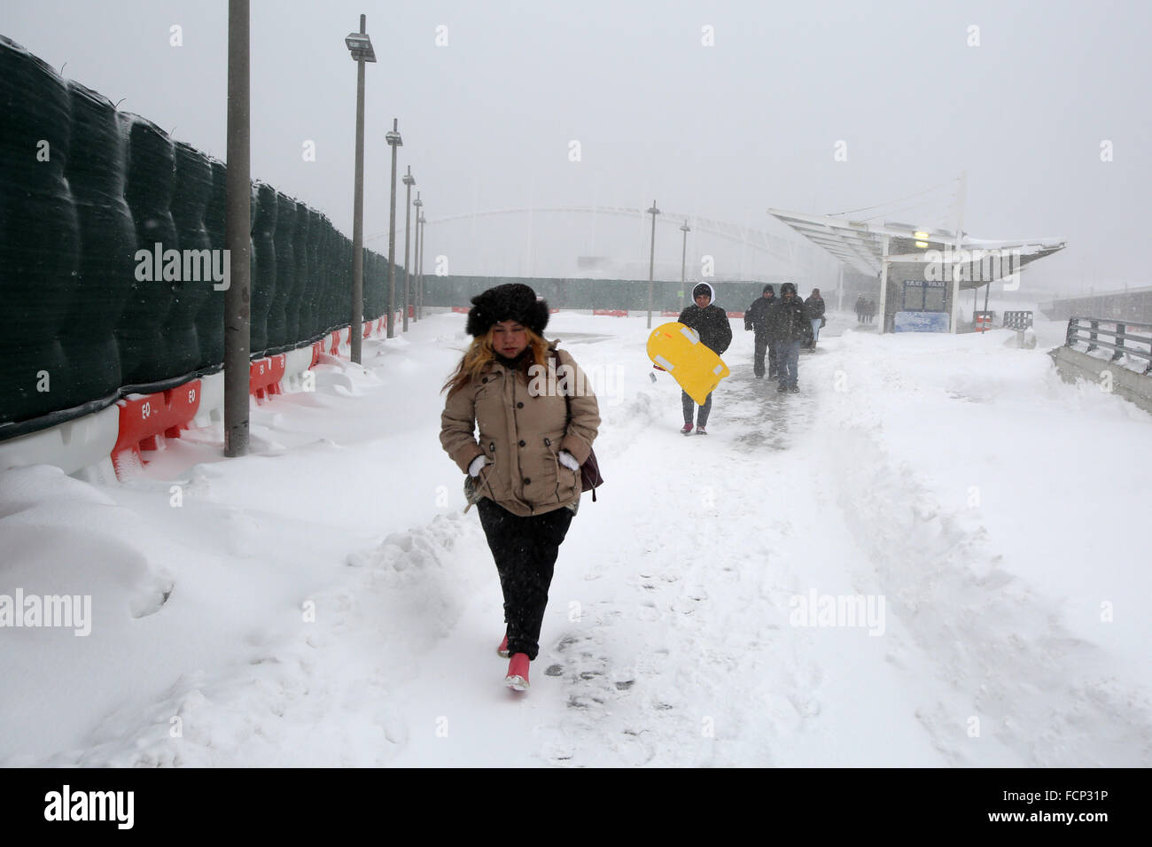 New York, New York, USA. 23rd Jan, 2016. People walk from the Staten Island Ferry St. George terminal from Manhattan during Winter Storm Jonas. A travel ban had been in place for hours, but the ferry still operated. Snowfall projections for Staten Island were approximately 12-18in, with winds gusting up to 50 miles an hour. Late afternoon, buses ceased to run and a travel ban was enforced by the NYPD. This lack of transportation stranded many residents of Staten Island who had taken the ferry home. People were forced to try and walk to their destination in the blizzard. New York Governor Cuo Stock Photo