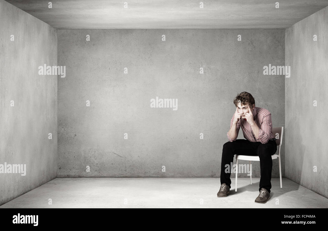 Depressed man sitting on a chair all alone Stock Photo - Alamy