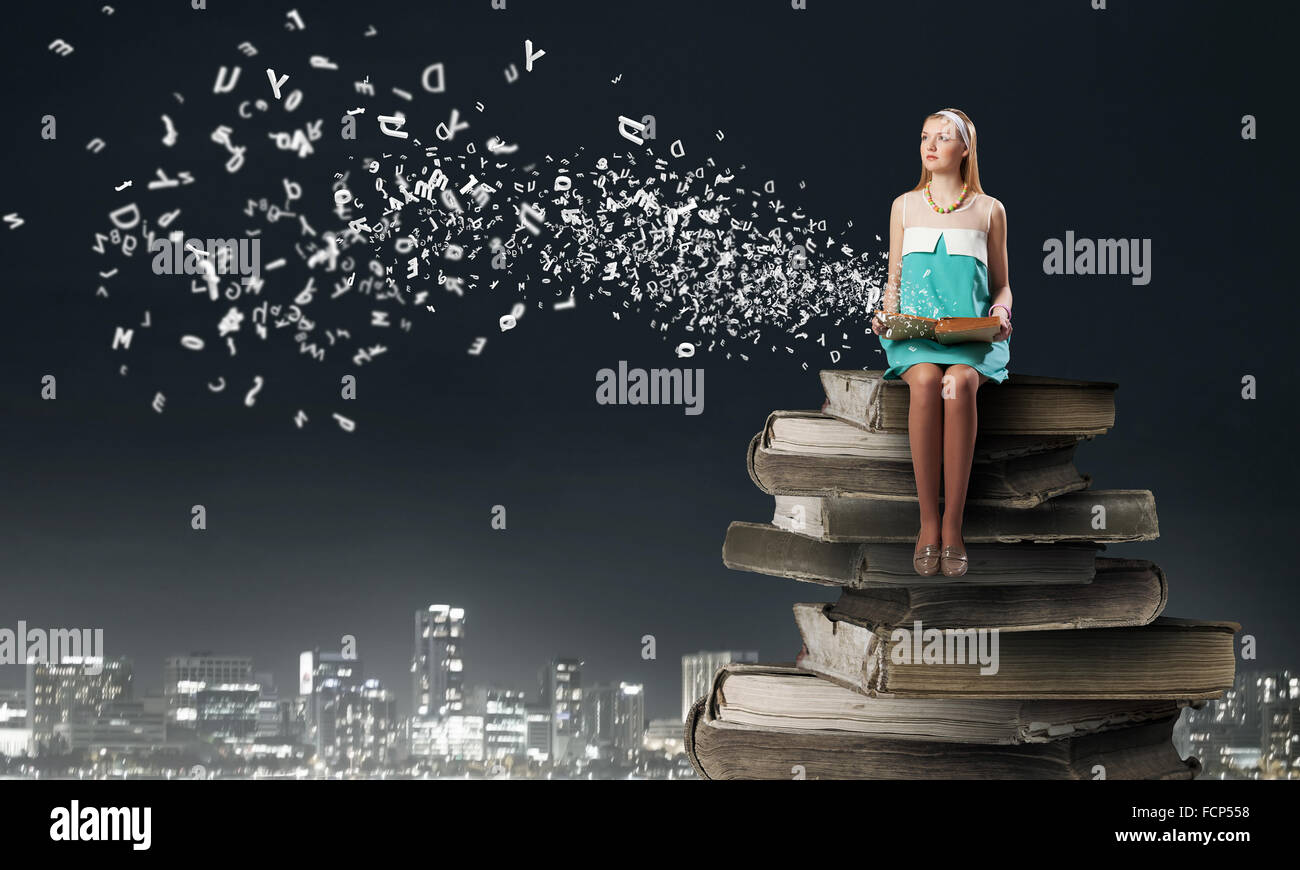 Young beautiful lady sitting on pile of old books Stock Photo - Alamy