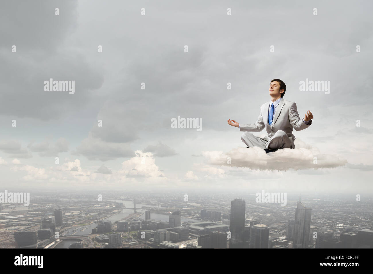Young businessman sitting on cloud high in sky and meditating Stock ...