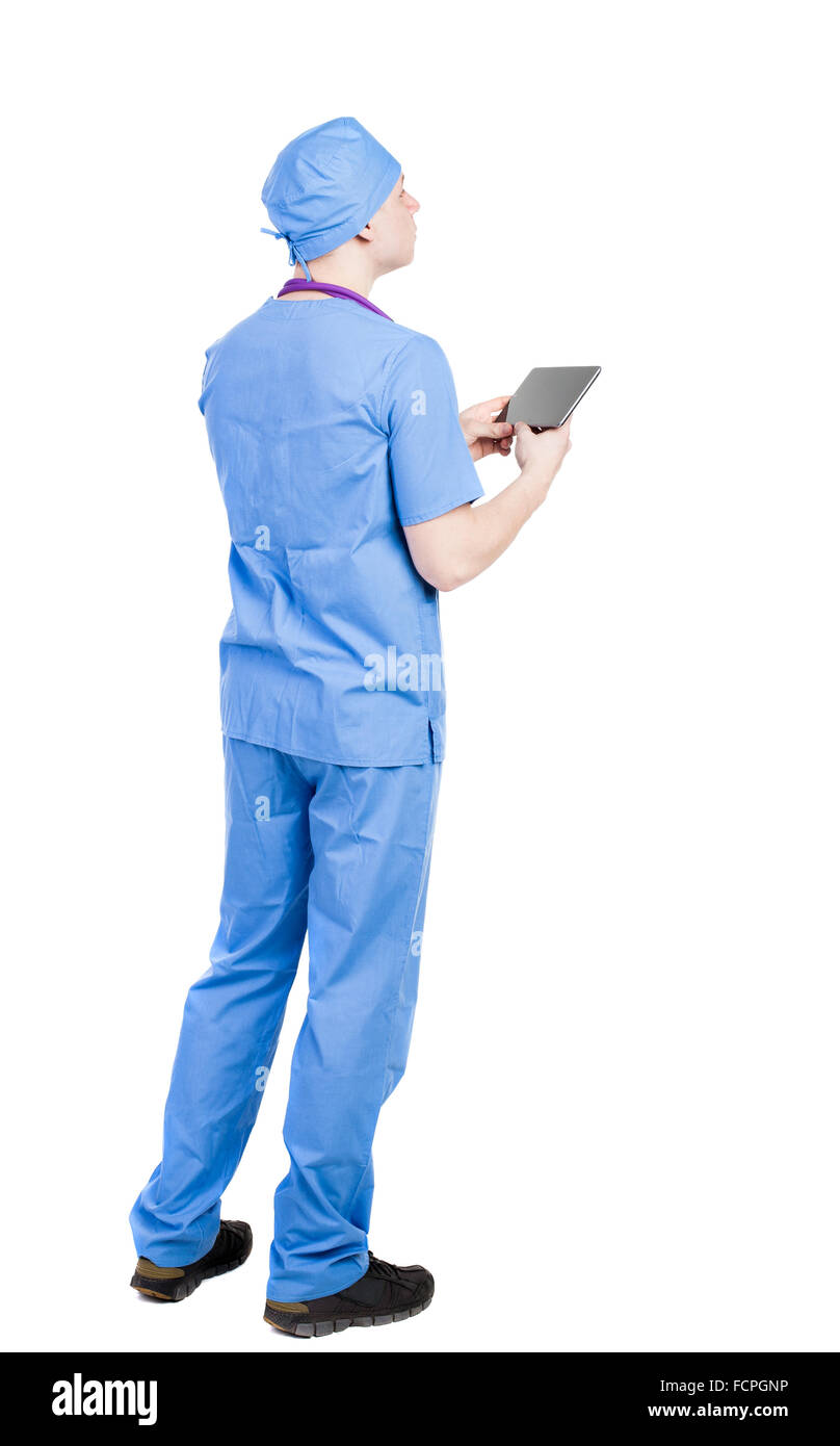 Back view of doctor in robe holding tablet computer. Standing young guy. Rear view people collection.  backside view of person. Stock Photo