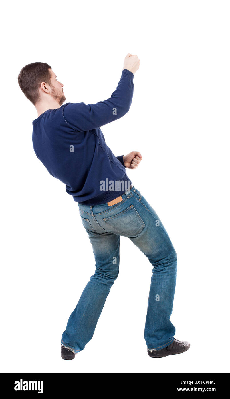 back view of standing man pulling a rope from the top or cling to  something. guy watching. Rear view people collection. backside view of  person. Isolated over white background. Man in jeans