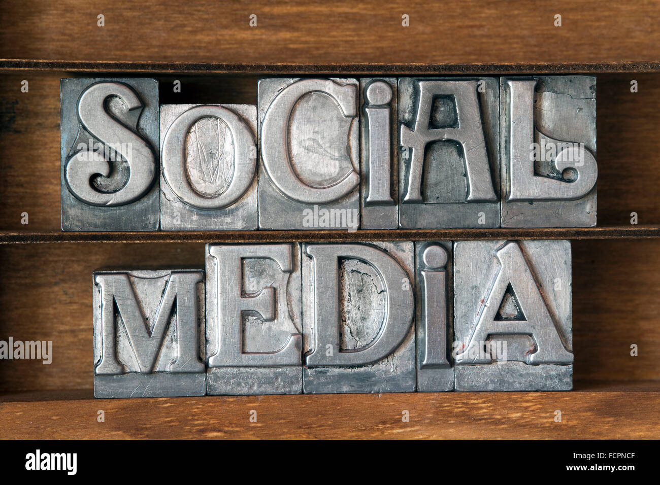 social media phrase made from metallic letterpress type on wooden tray