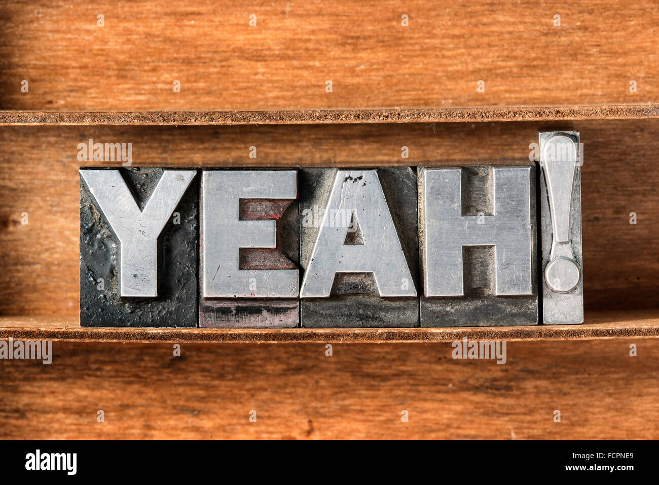 yeah exclamation made from metallic letterpress type on wooden tray Stock Photo
