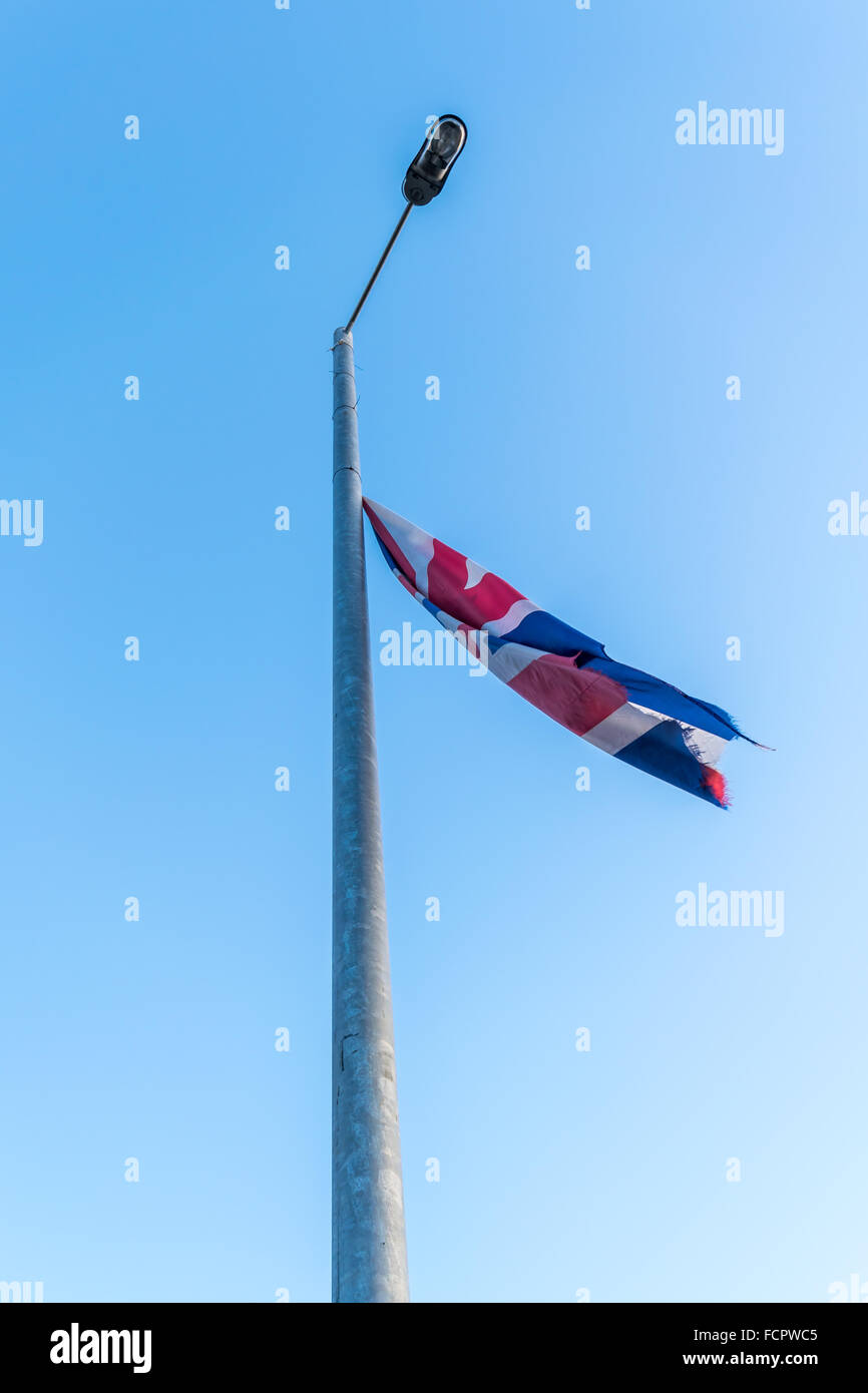 A torn an tattered Union jack flag flies from a Belfast lamppost. Stock Photo