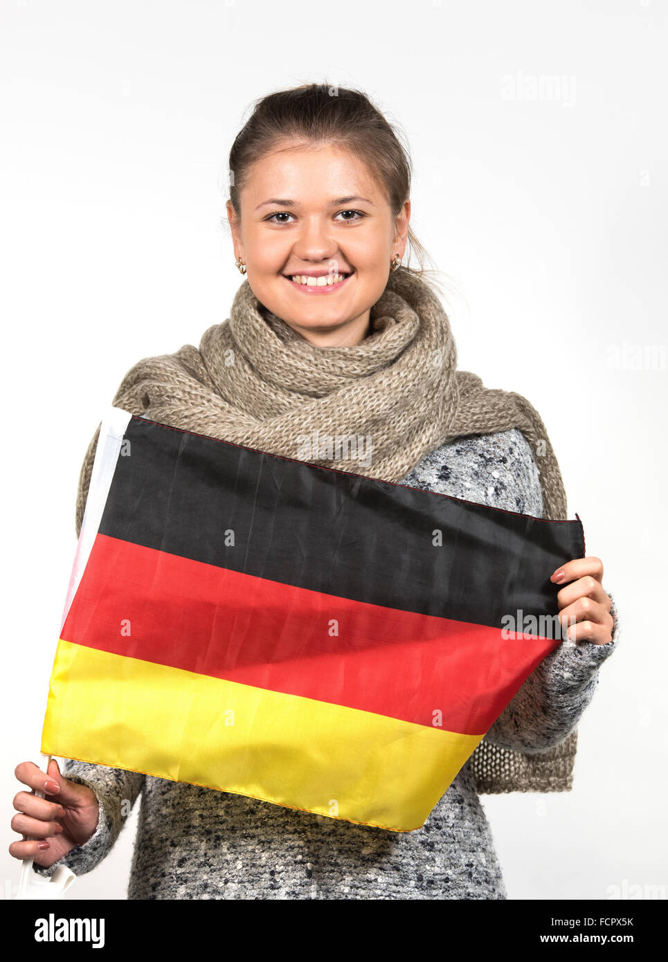 young woman wearing winter clothes, holding german flag Stock Photo Alamy