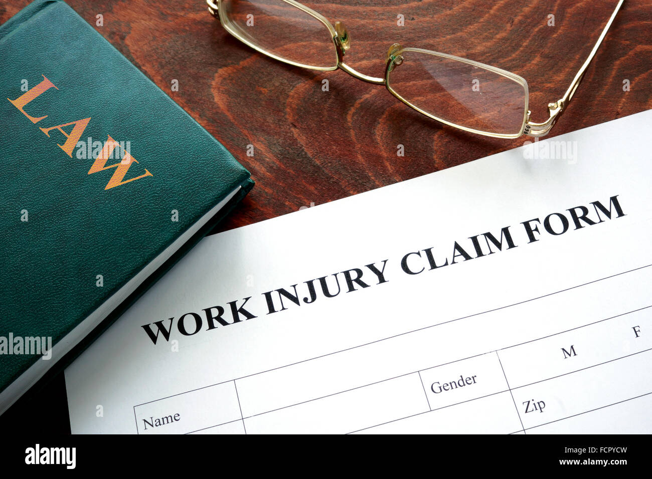 Work injury claim form on a wooden table. Stock Photo