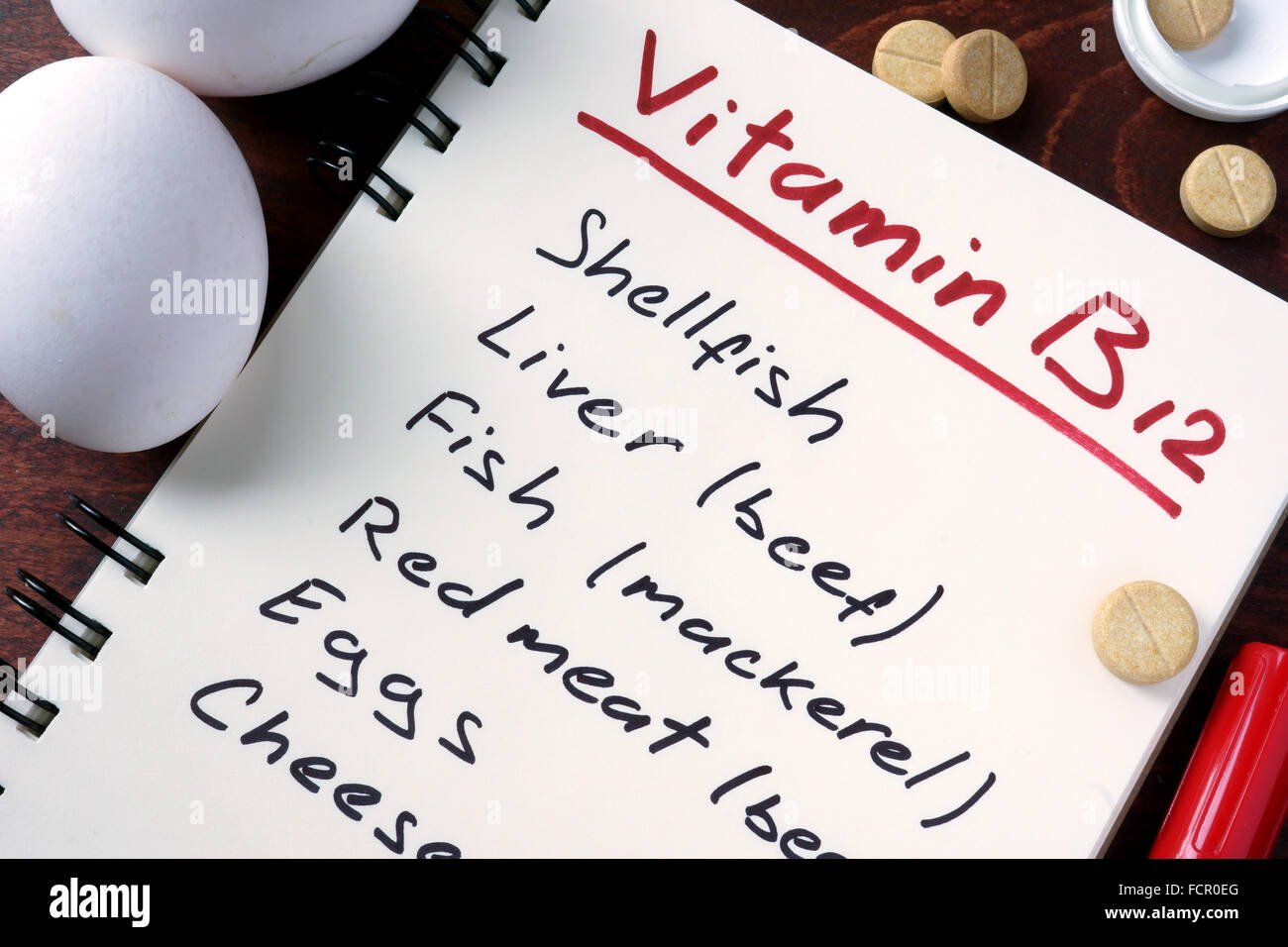 Notepad with vitamin b12  and pills on the table. Stock Photo