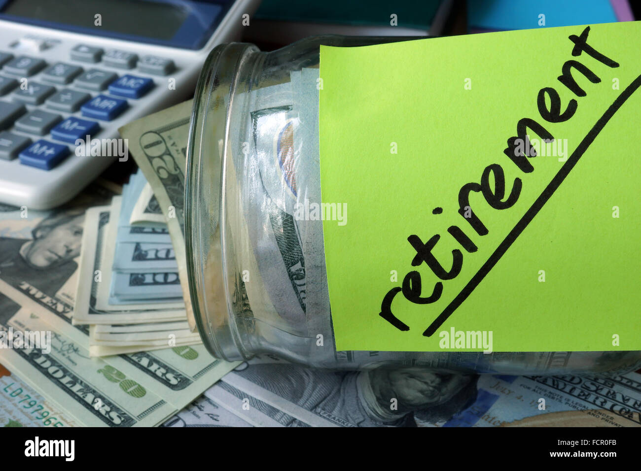 Jar with label Retirement Plan and money on the table. Saving money concept. Stock Photo