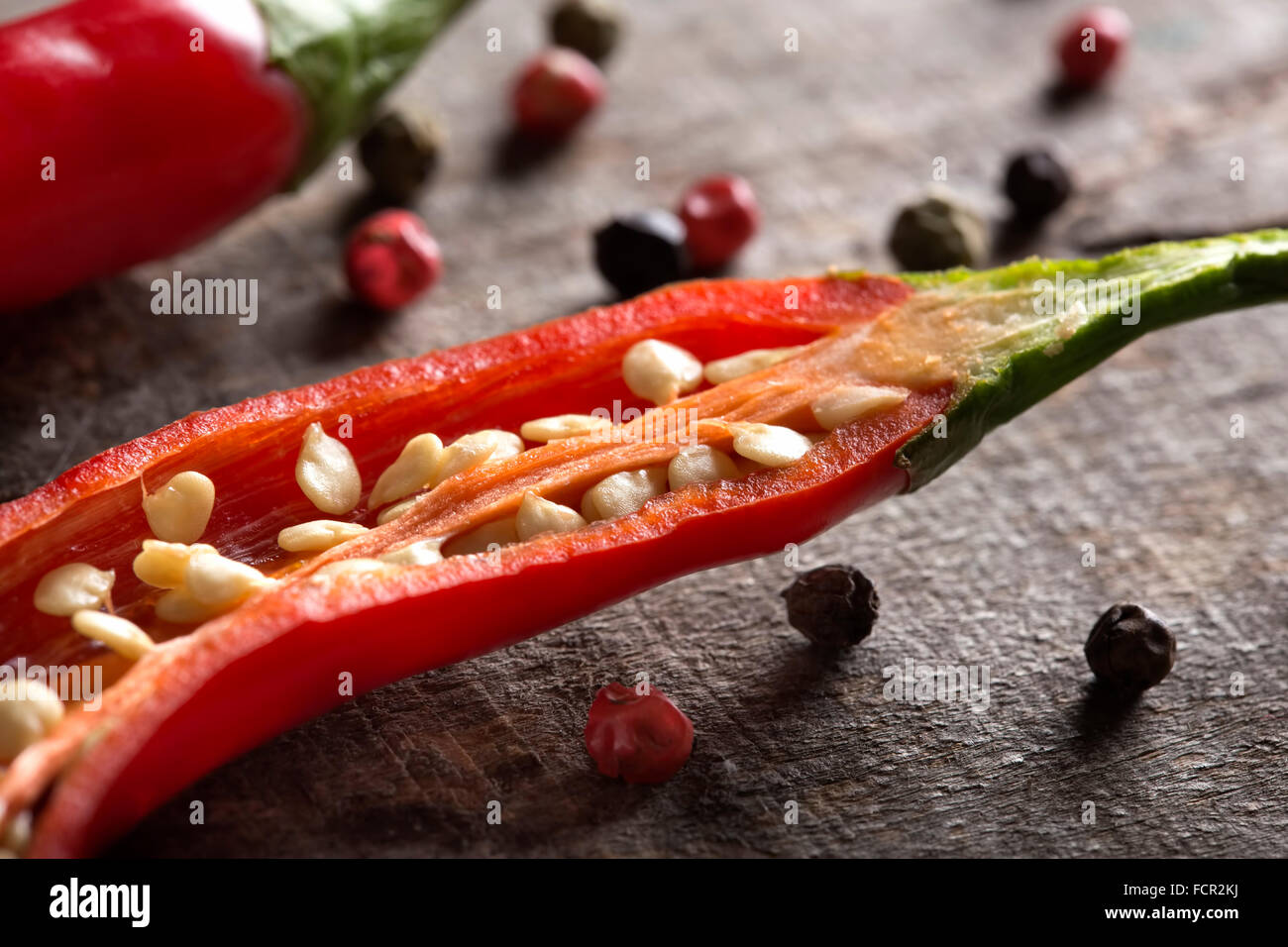 Red chili peppers on wood with peppercorns Stock Photo