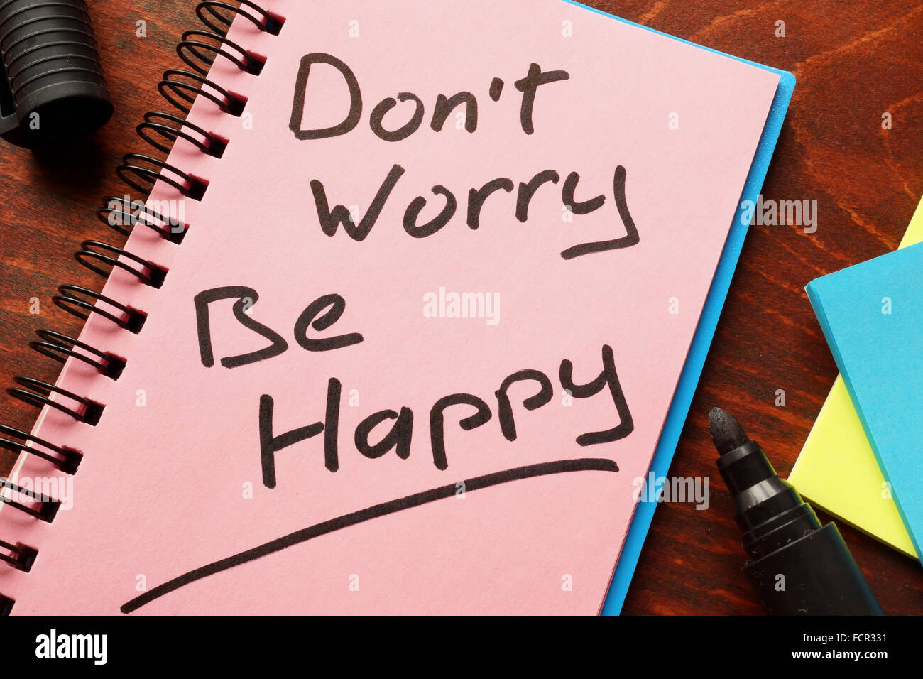 Notebook with the words Don’t worry Be happy  on the table. Stock Photo
