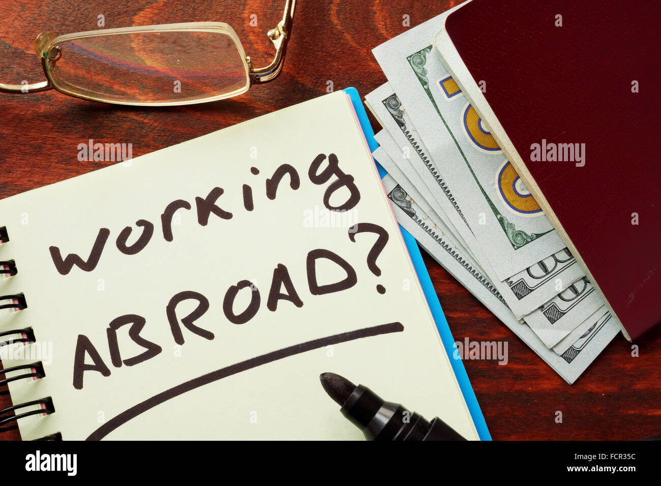 Notebook with the words  Working abroad on the table. Stock Photo