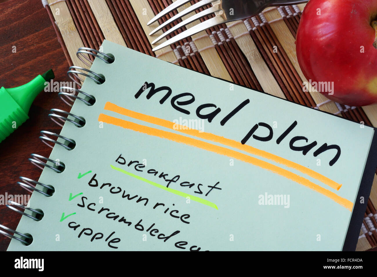 Notepad with meal plan and apple. Diet planning. Stock Photo