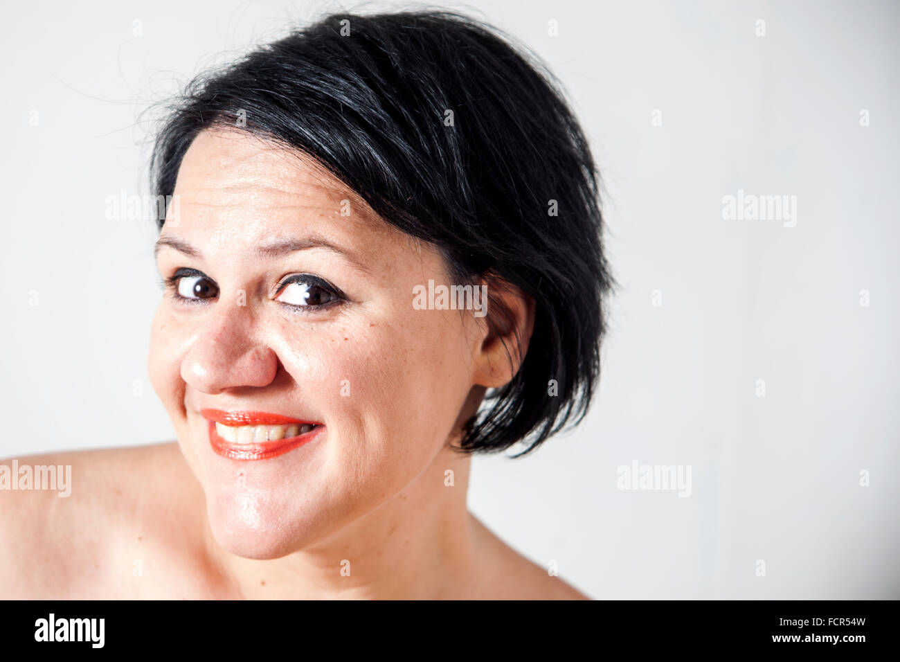 Short Dark Haired Girl Smiling On White Background Stock Photo