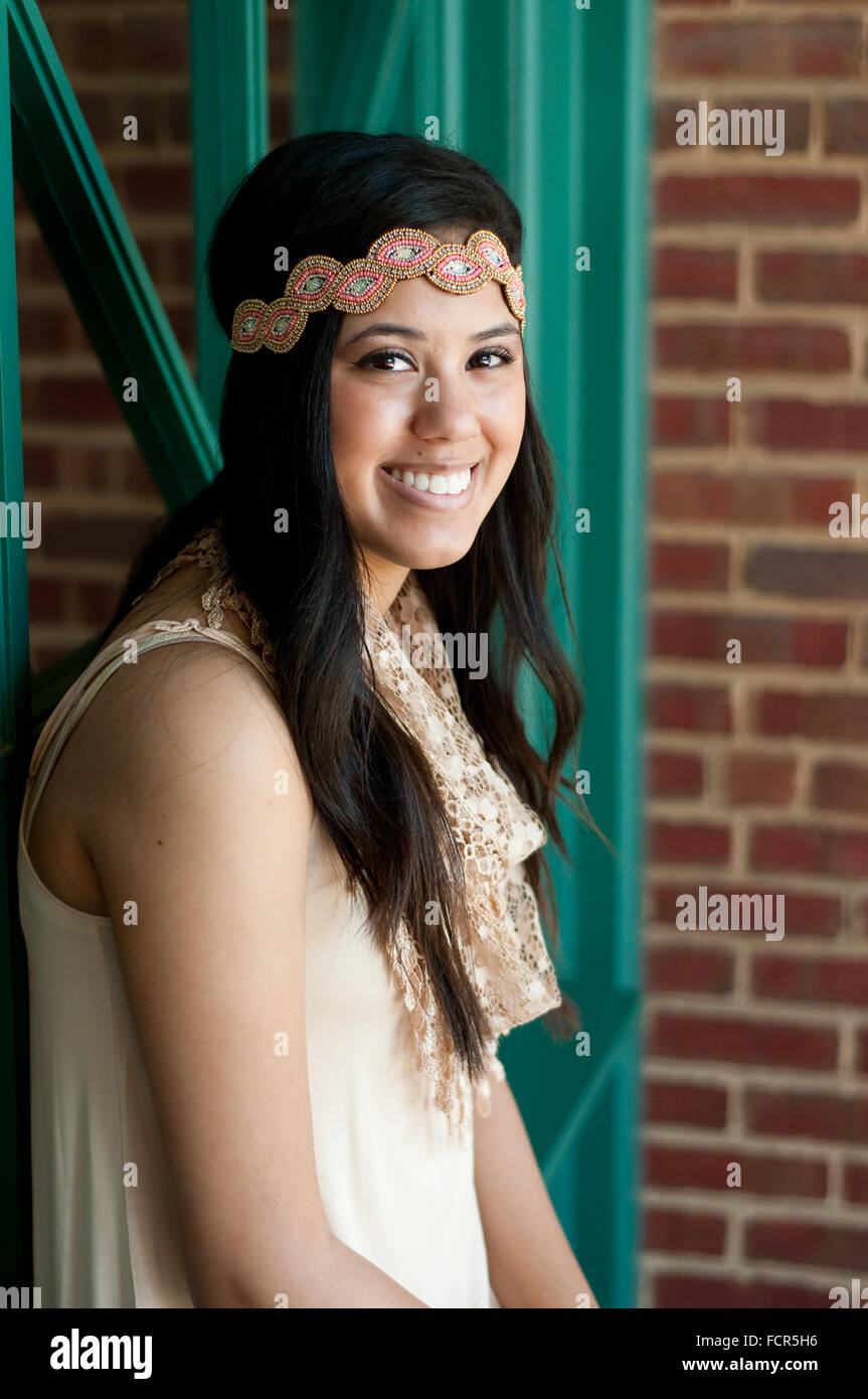 Happy teen girl looking up at camera with a headband, wearing a dress