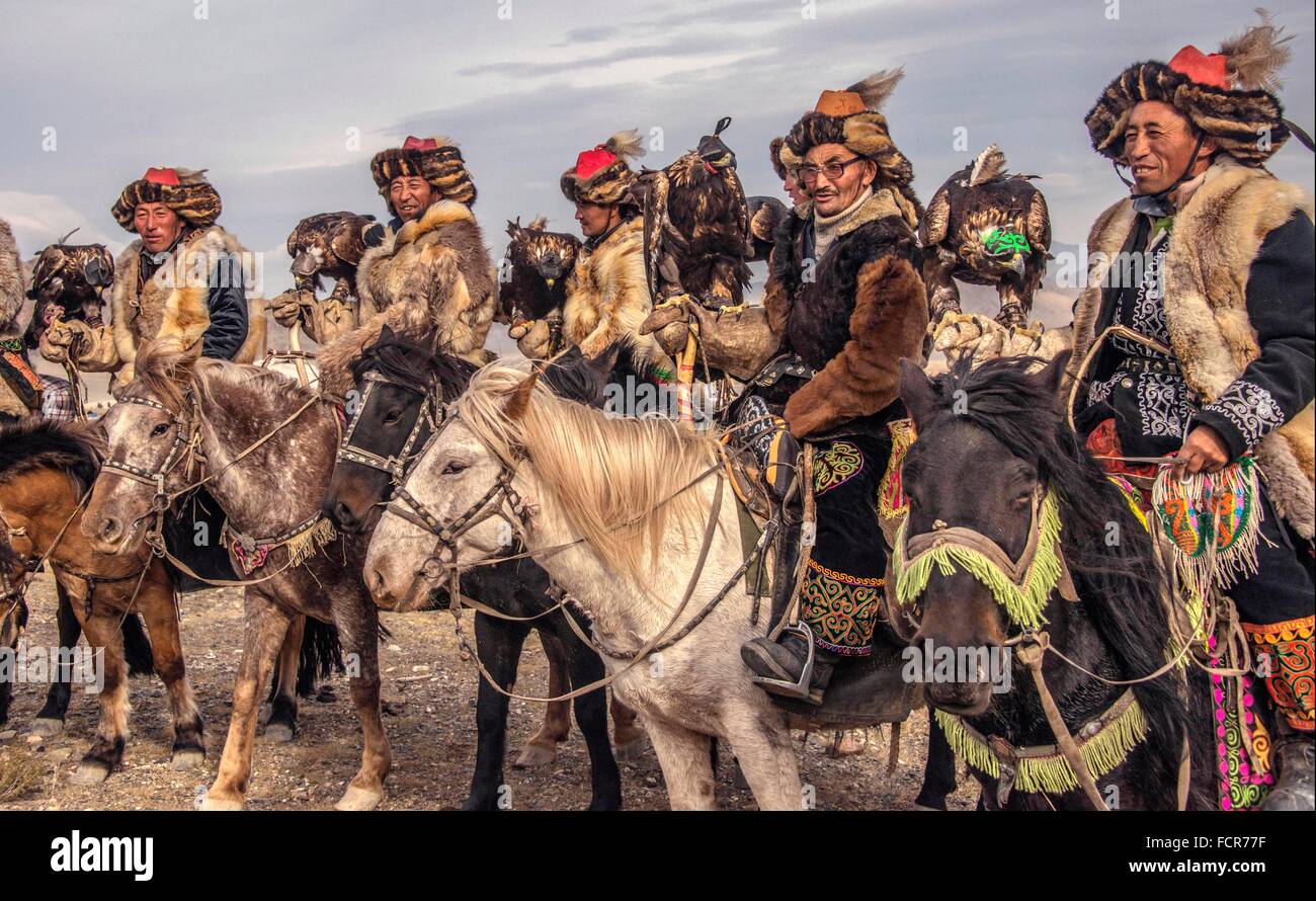 Kazakh Burkitshi hunters pose on horseback during the Mongolian Golden Eagle Festival in Olgii, Mongolia. Stock Photo