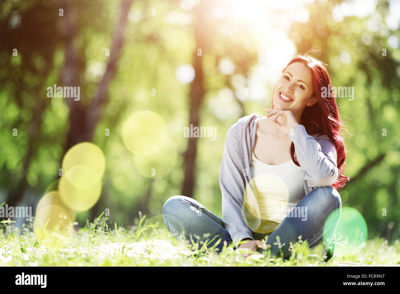 Pretty girl in summer park sitting on grass Stock Photo - Alamy