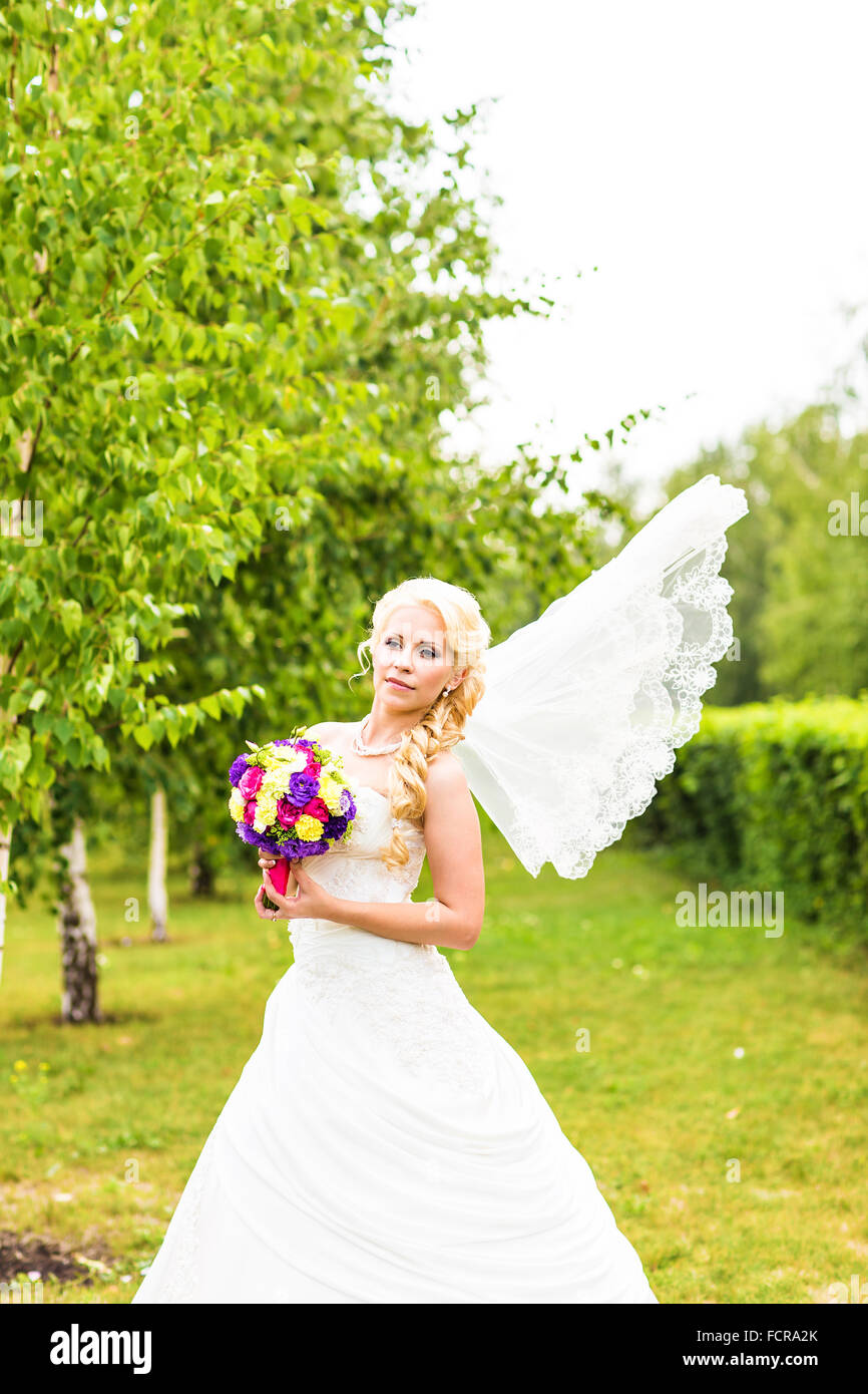 Happy bride with wedding bouquet outdoors Stock Photo - Alamy