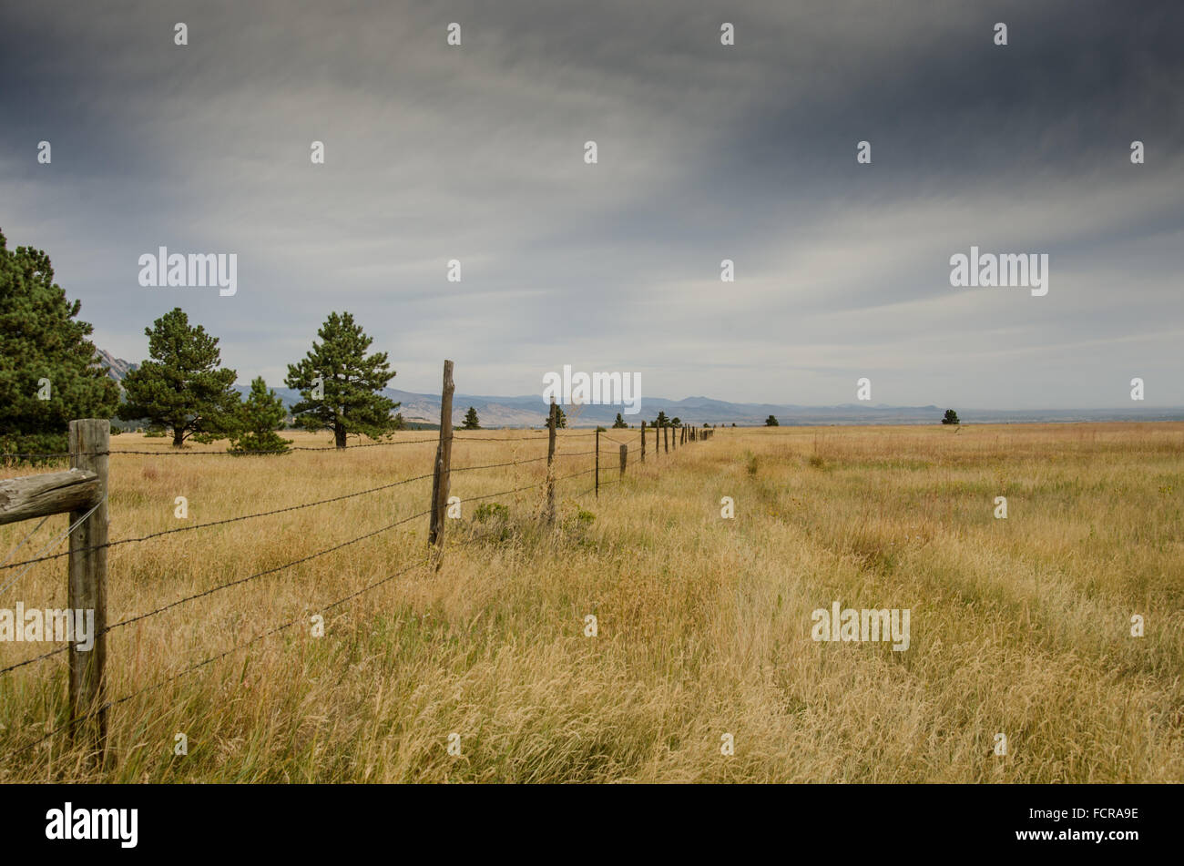An old barbed wire fence separates two dry fields in the recreation ...