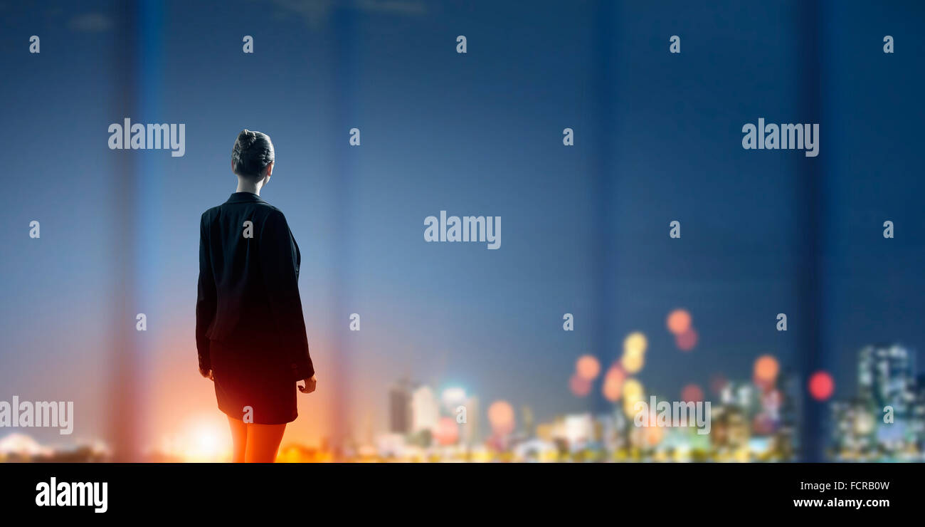 Rear view of businesswoman looking at night city Stock Photo - Alamy