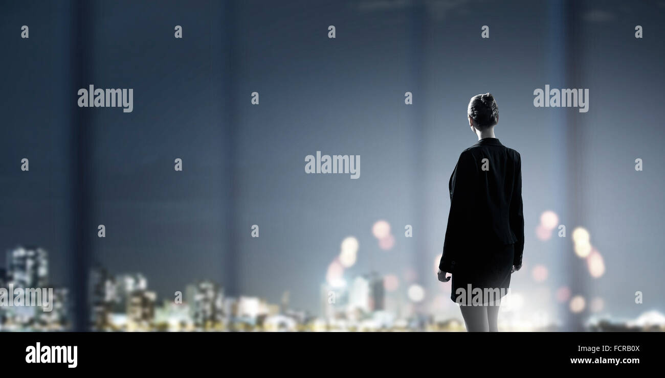 Rear view of businesswoman looking at night city Stock Photo - Alamy