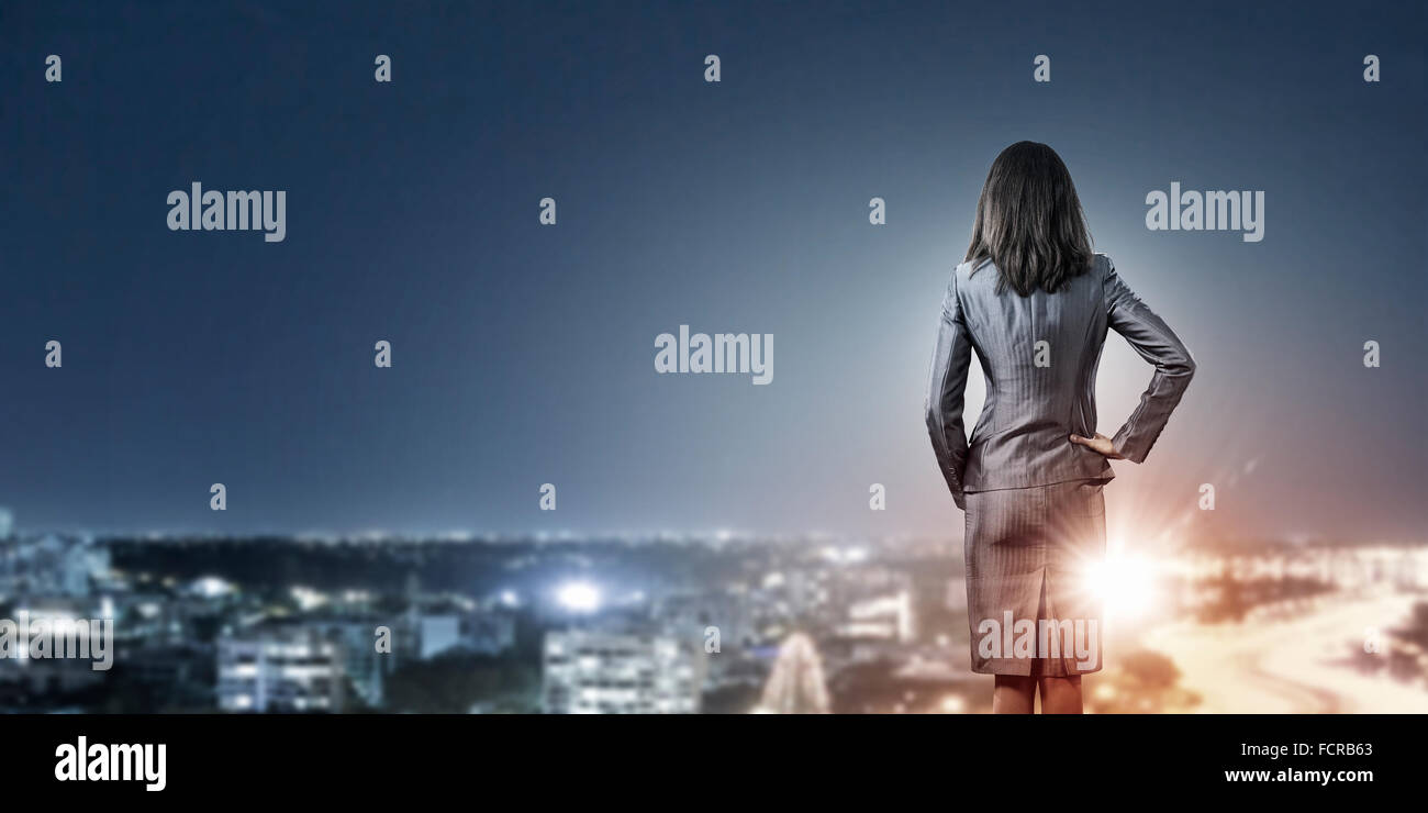 Rear view of businesswoman looking at night city Stock Photo - Alamy