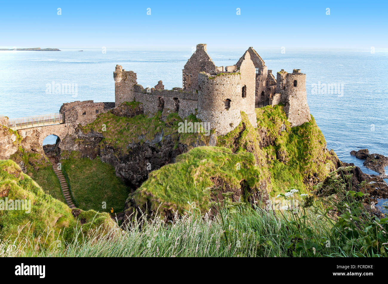 Ruins of medieval Dunluce Castle, County Antrim, Northern Ireland, at sunrise light Stock Photo