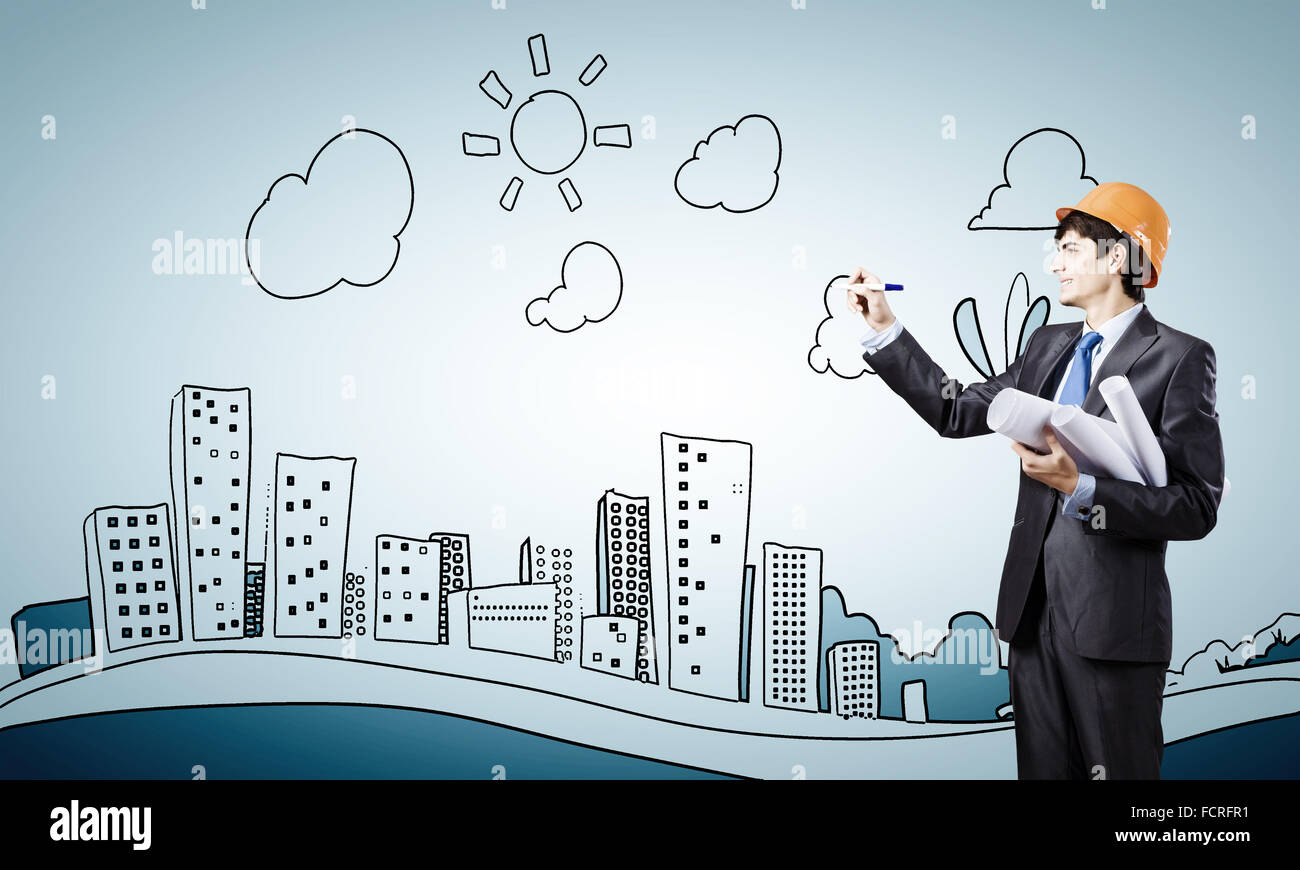 Young man engineer in helmet drawing construction project Stock Photo ...