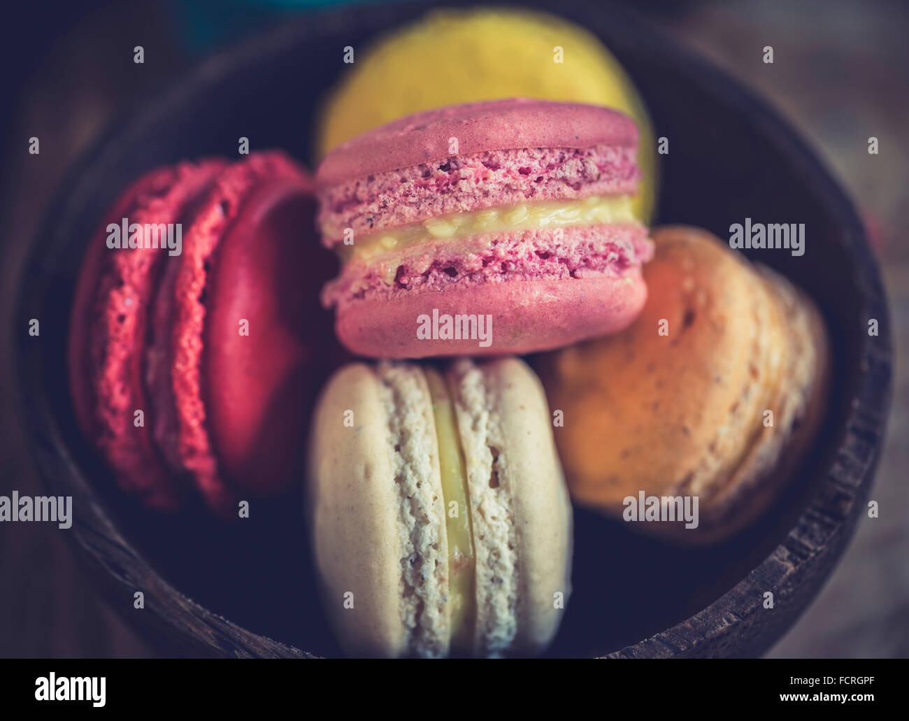 Sweet colorful macaroons cookies in wooden bowl,selective focus on the front Stock Photo