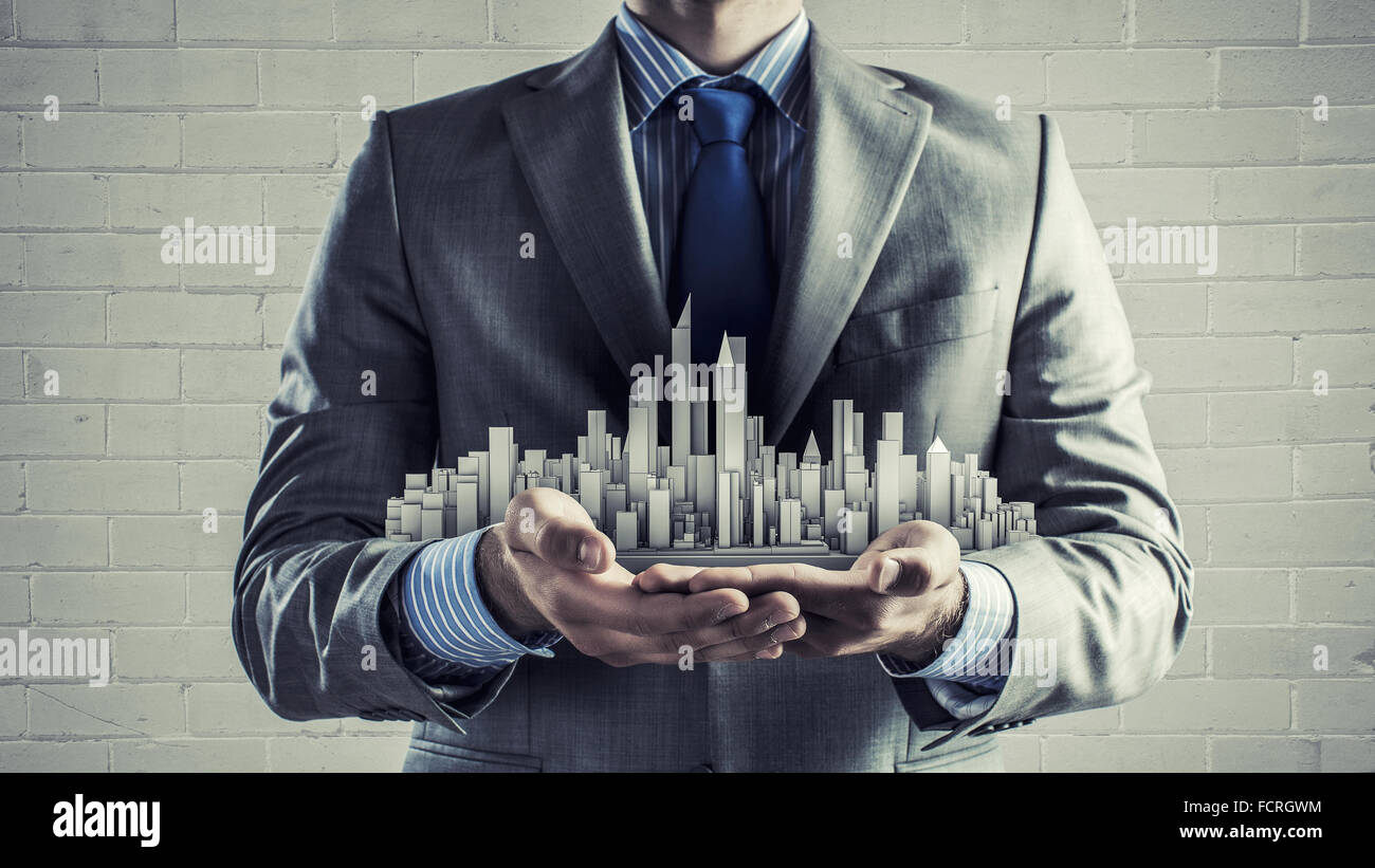 Close up of businessman hand holding construction model Stock Photo