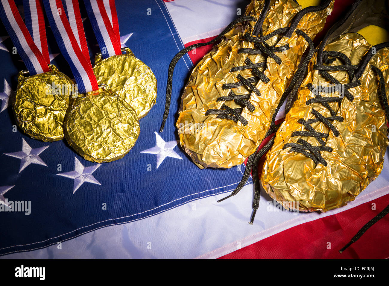 Golden shoes sit next to a matching collection of gold medals on the