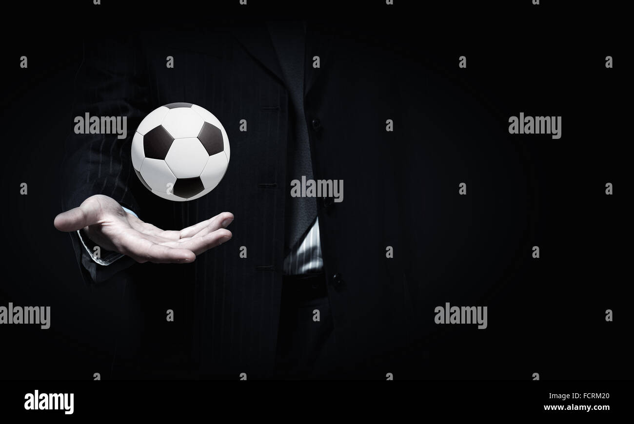 Close up of elegant businessman holding soccer ball in hand Stock Photo ...
