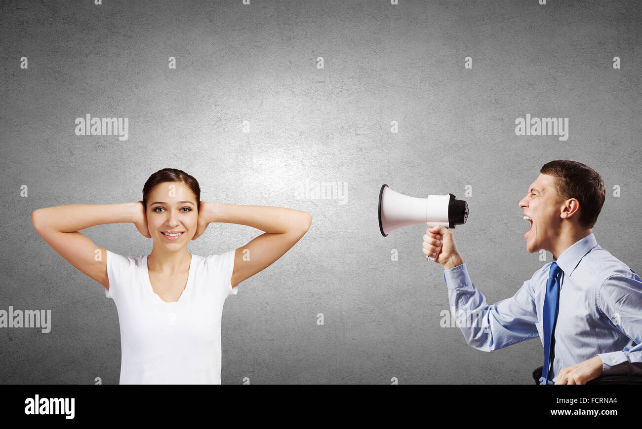 Young furious man screaming agressively in megaphone Stock Photo
