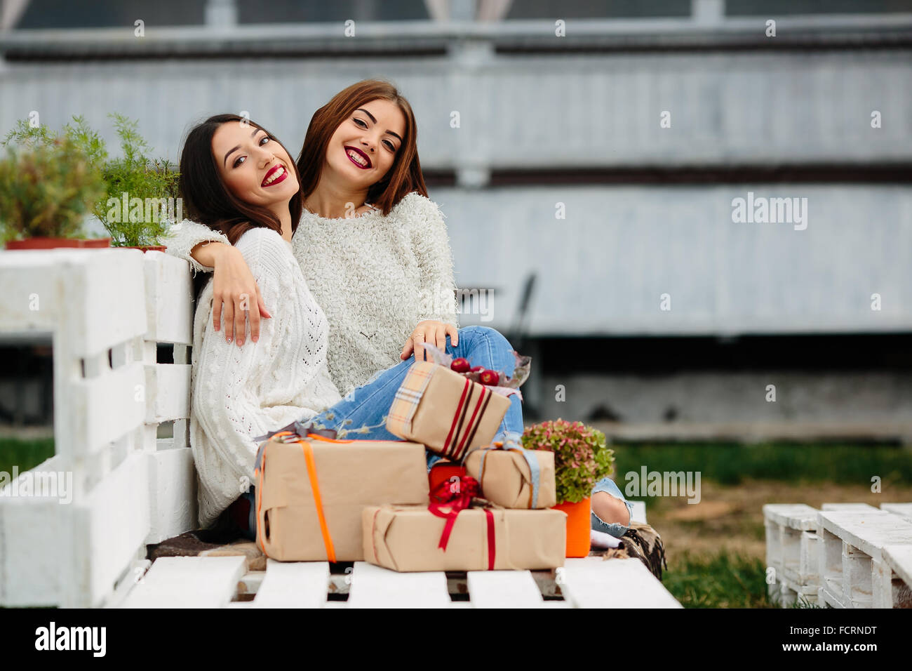 Two beautiful girls sitting on a bench Stock Photo - Alamy