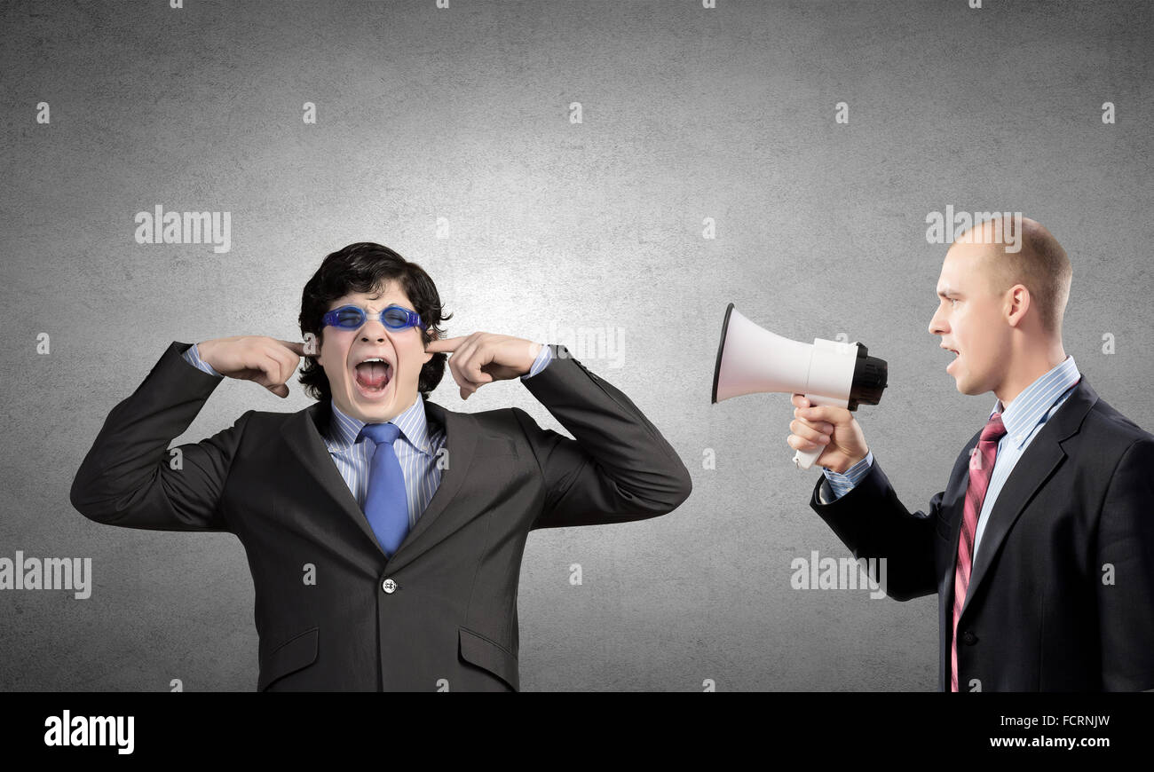 Young furious man screaming agressively in megaphone Stock Photo