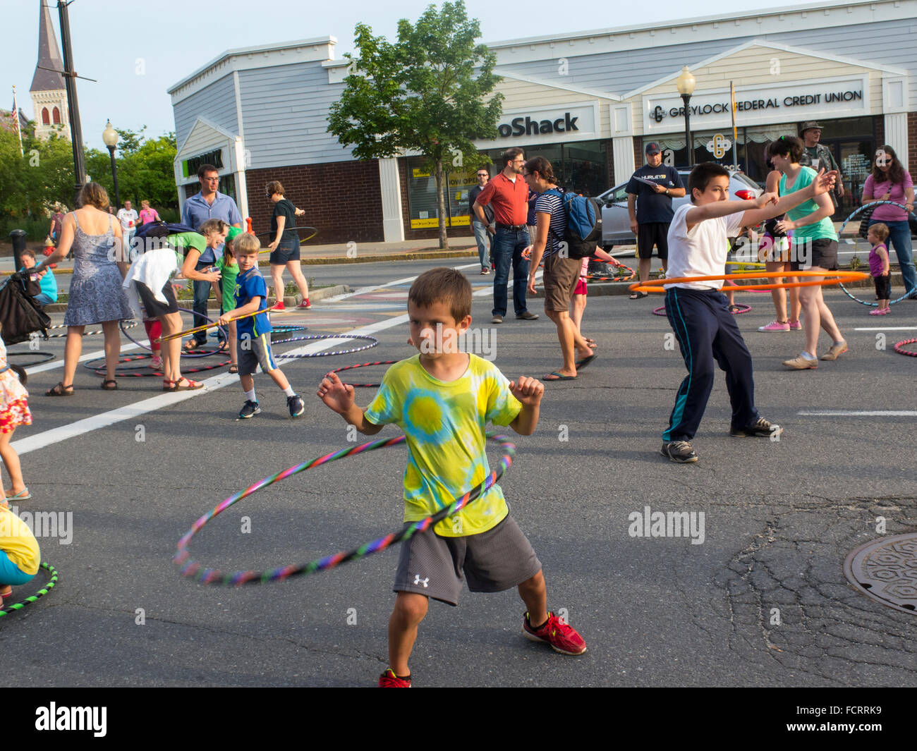 Kids and adults trying out hula hoops at an art event in North Adams, Massachusetts. Stock Photo