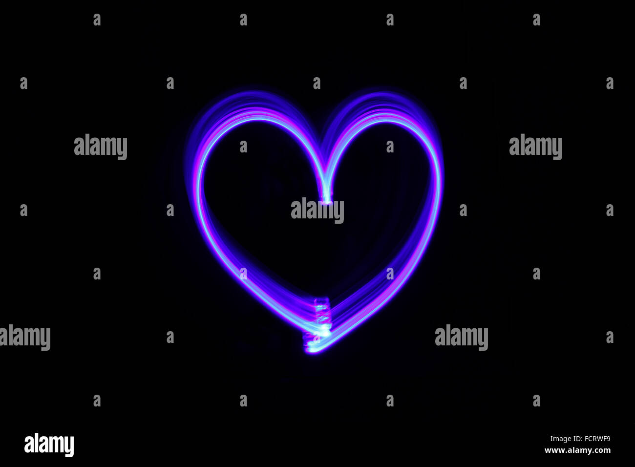 Drawing heart with light in the dark Stock Photo
